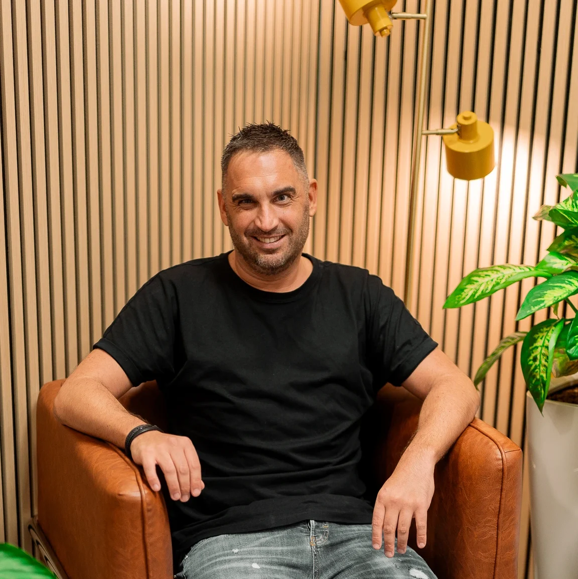DJ Benny vor Loungwand im Büro