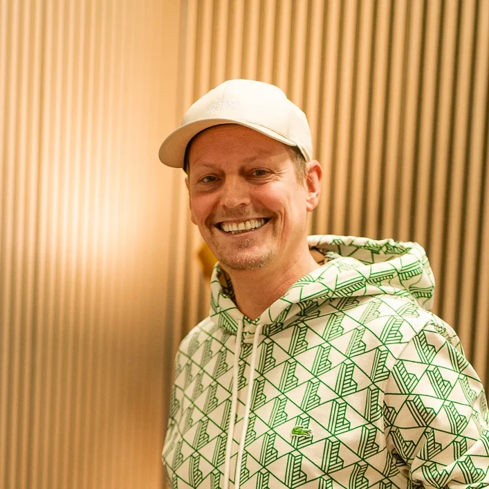 DJ Arnold ganz privat in Klamotten lächelt