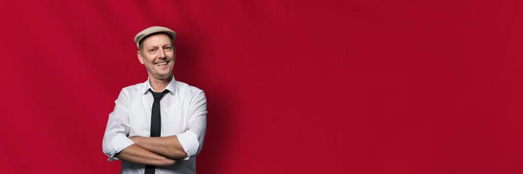Hochzeits DJ Arnold vor rotem Hintergrund