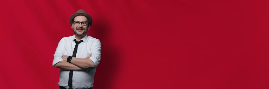 Hochzeits DJ Basti vor rotem Hintergrund