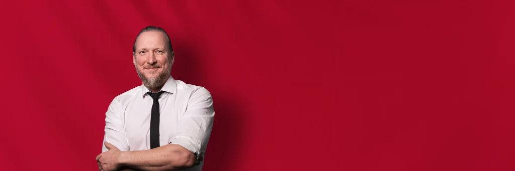 DJ Markus vor rotem Hintergrund