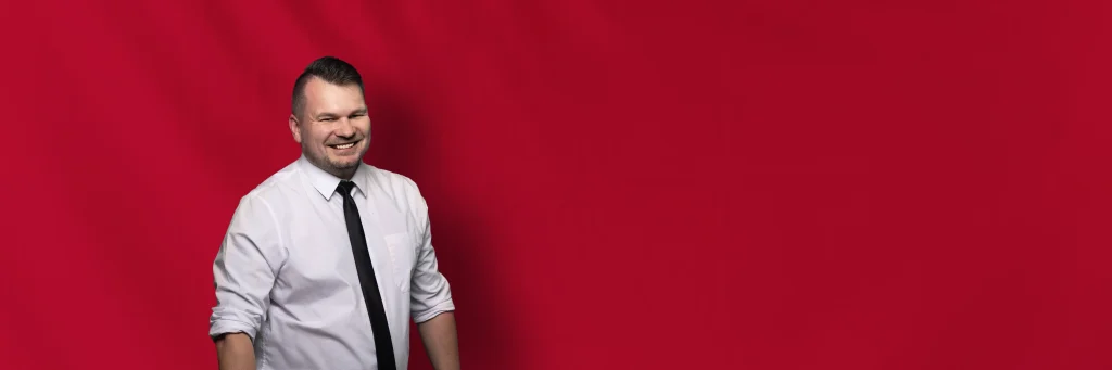 DJ Tomasz vor rotem Hintergrund
